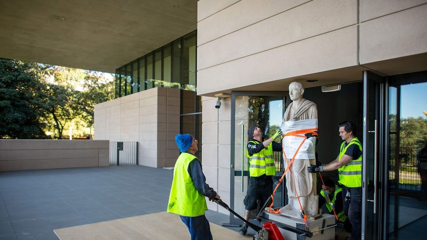 Project Officer Luke Parker coordinates the move of a granite statue