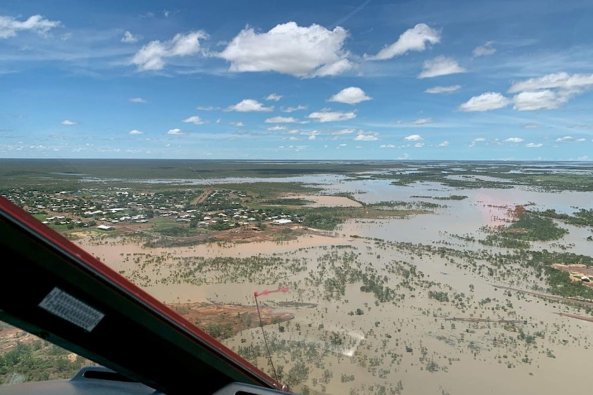 An aerial photo of brown floodwater encroaching on the township of Normanton.