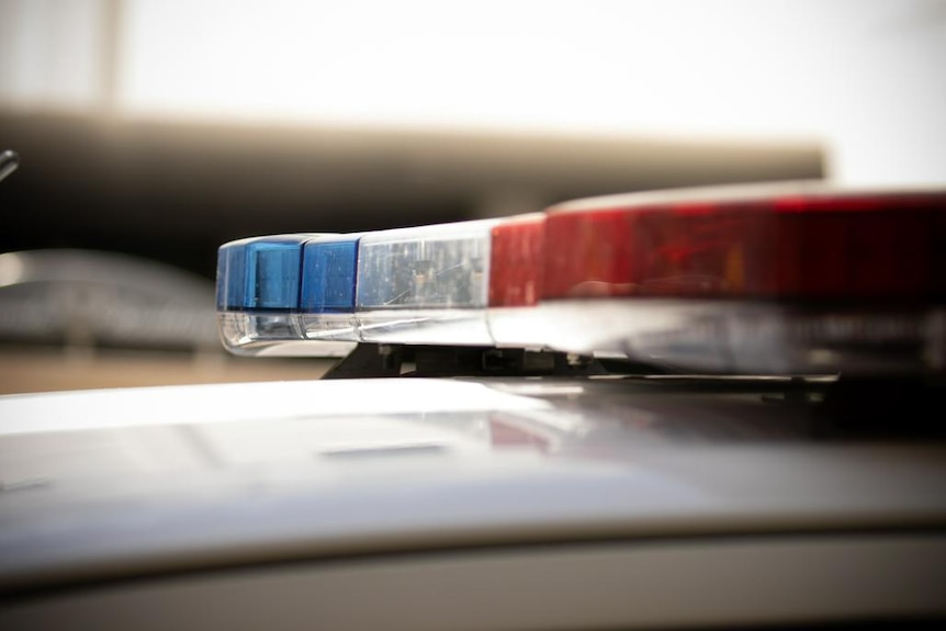 A close-up of the blue and red lights on the top of a police car, unlit.