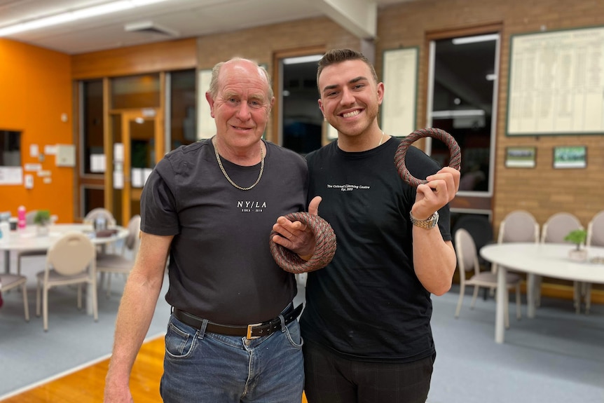 Cute photo of an older man in his 70s and young man 20s holding quoits