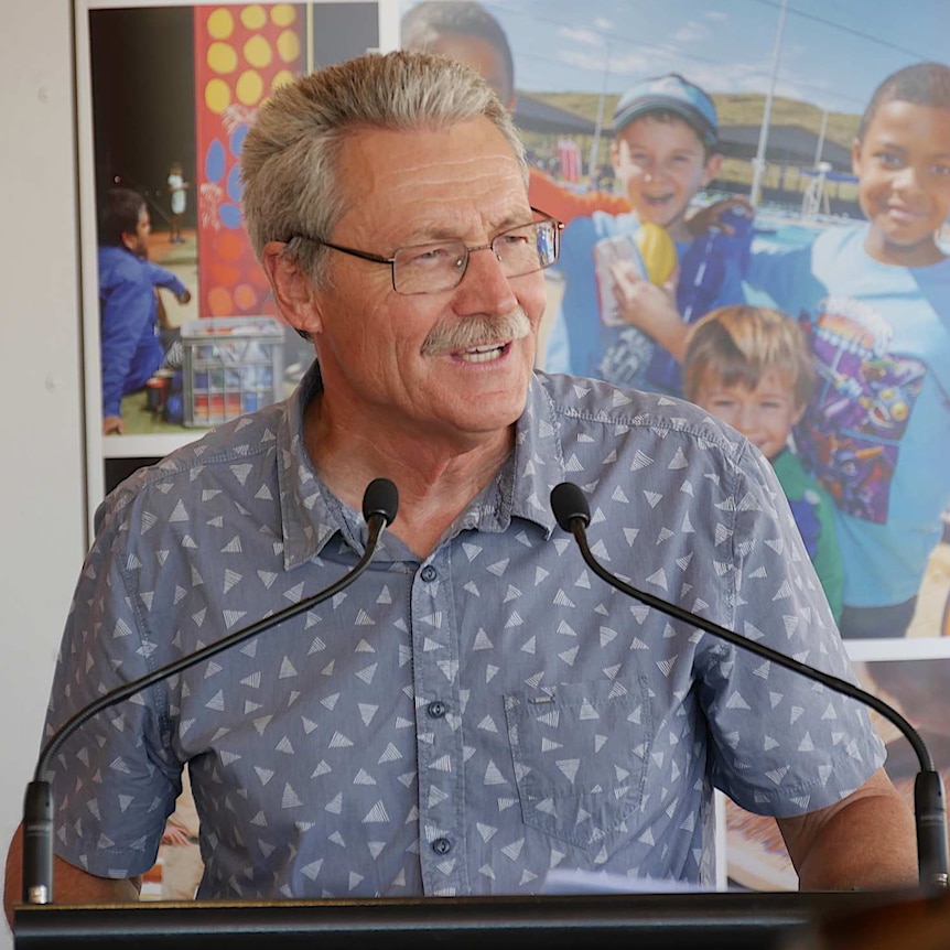 A man speaking at a microphone.