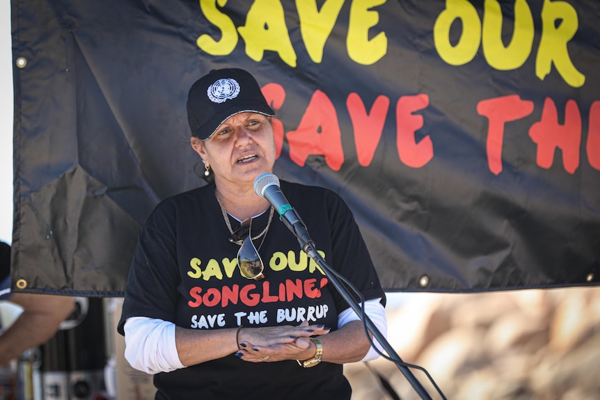An Aboriginal woman speaks at a march about protecting cultural heritage