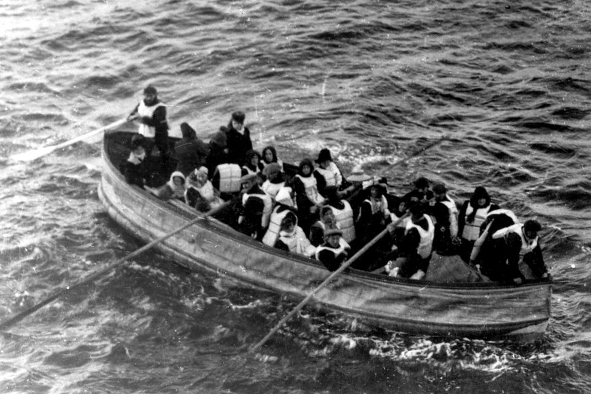 A lifeboat full of survivors pulls up next to the RMS Carpathia.