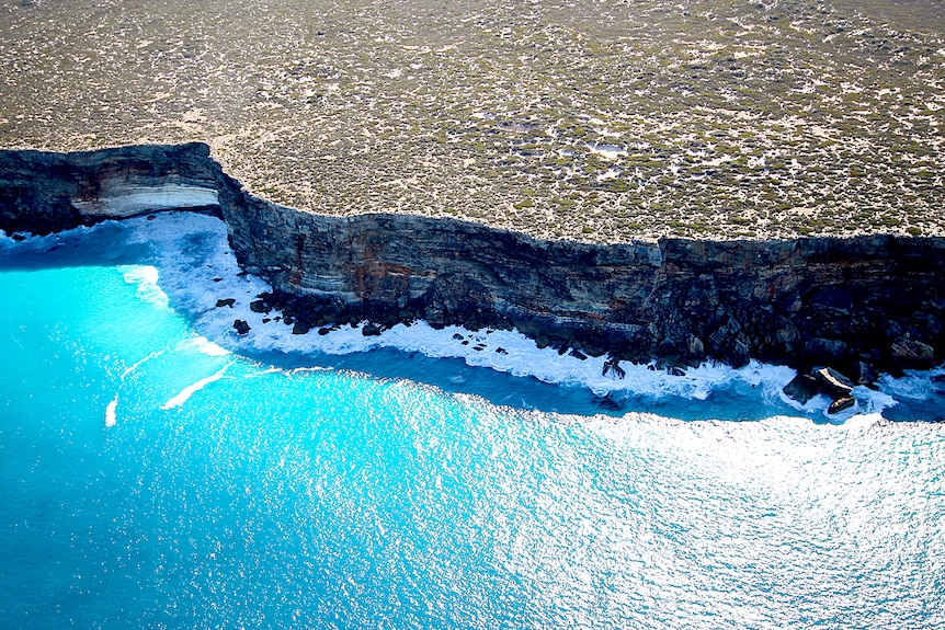 An aerial shot of cliffs next to the ocean.