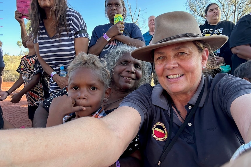 Sefie of woman in a crowd out bush.