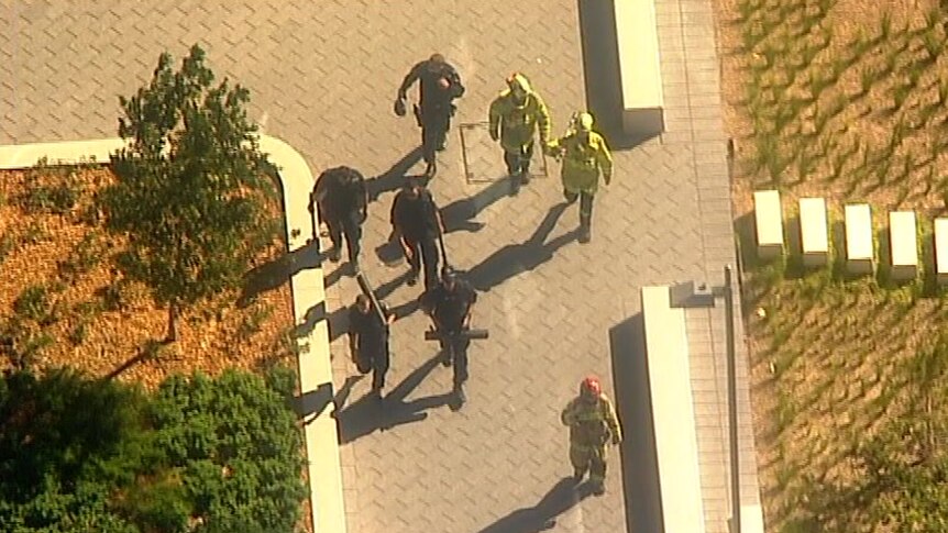 An aerial photo of emergency crews walking on pavement.