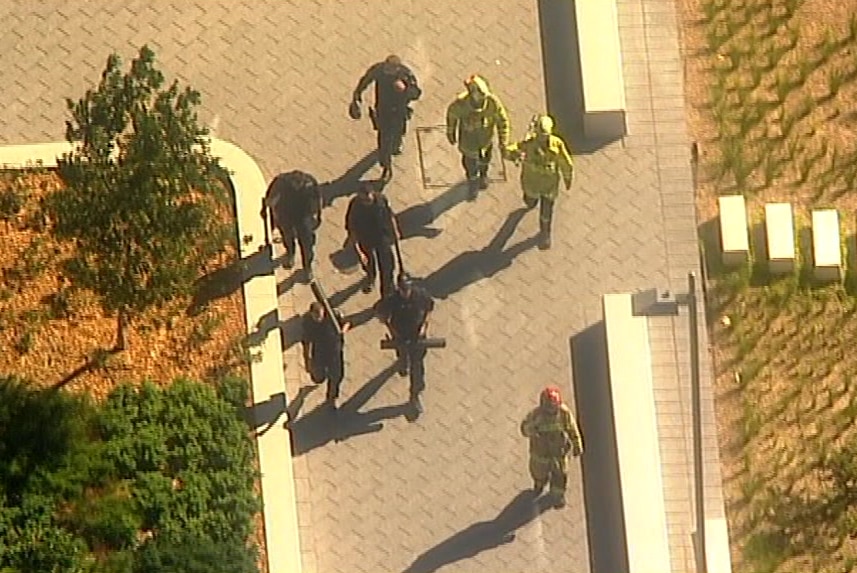 An aerial photo of emergency crews walking on pavement.
