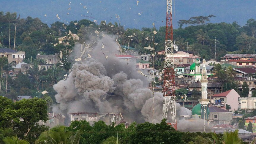 Debris flies in the air as Philippine Air Force fighter jets bomb suspected locations of Muslim militants in Marawi.