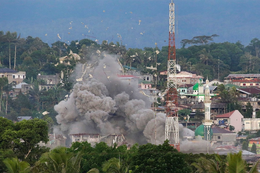 Debris flies in the air as Philippine Air Force fighter jets bomb suspected locations of Muslim militants in Marawi.