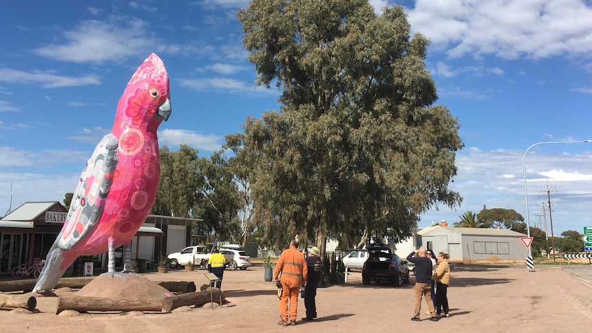 A large statue of a pink galah.