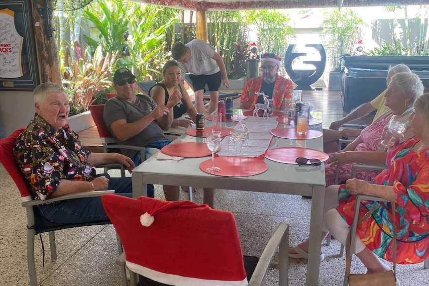 A group of people sitting outdoors with Christmas decor