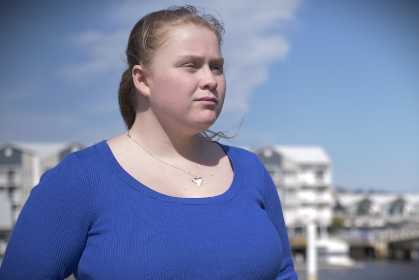 A young woman looks away from the camera.