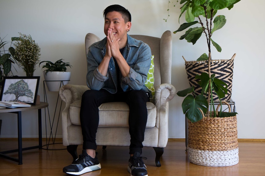 Mikey sitting on chair next to plants.