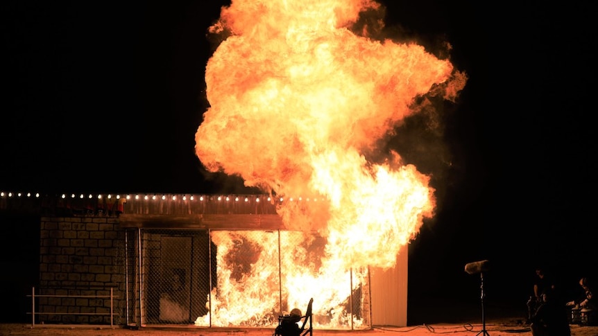 Huge flames around a burning building.