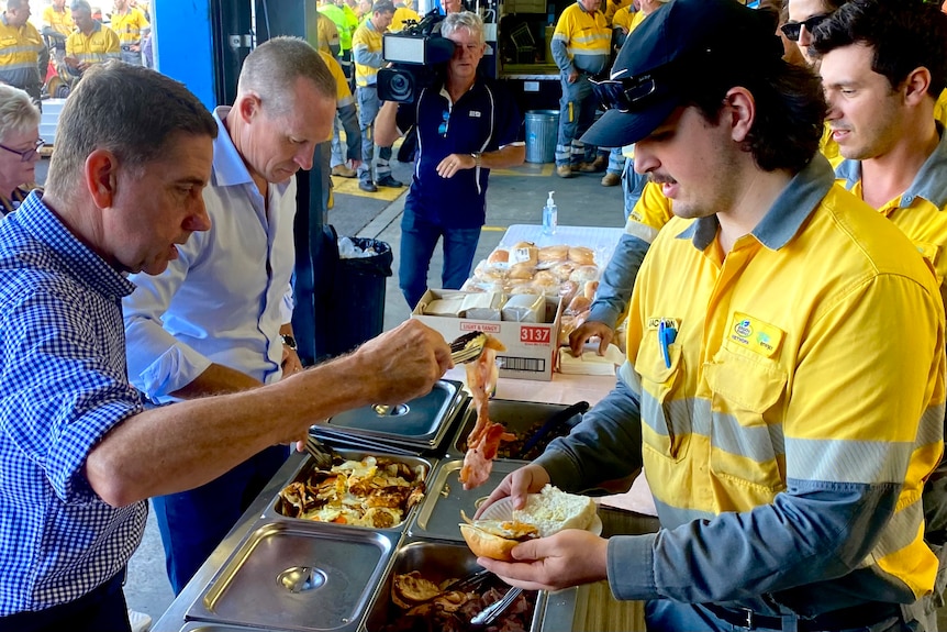 Politicians serve bacon and egg to energy workers in uniform