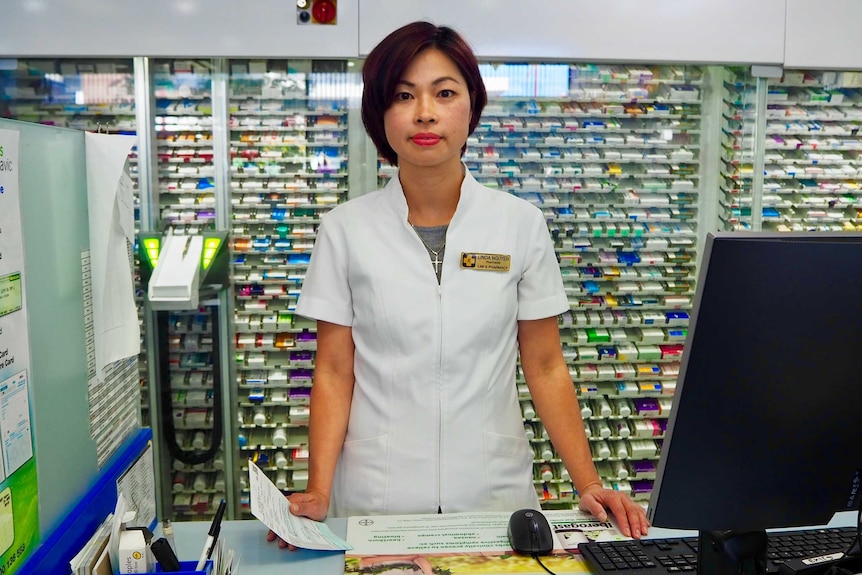 Pharmacist Linda Nguyen standing at the counter of her pharmacy.