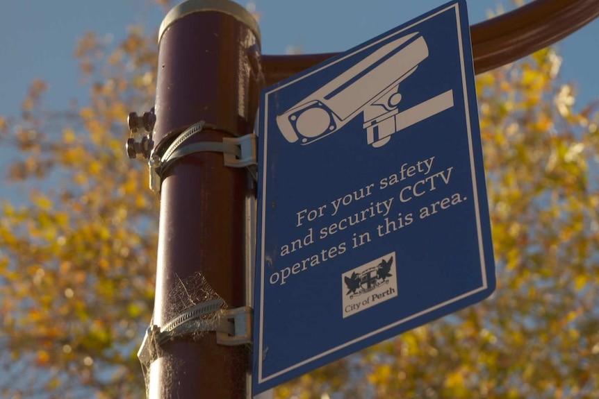A sign on a lamp post warning people that CCTV operates in the area.