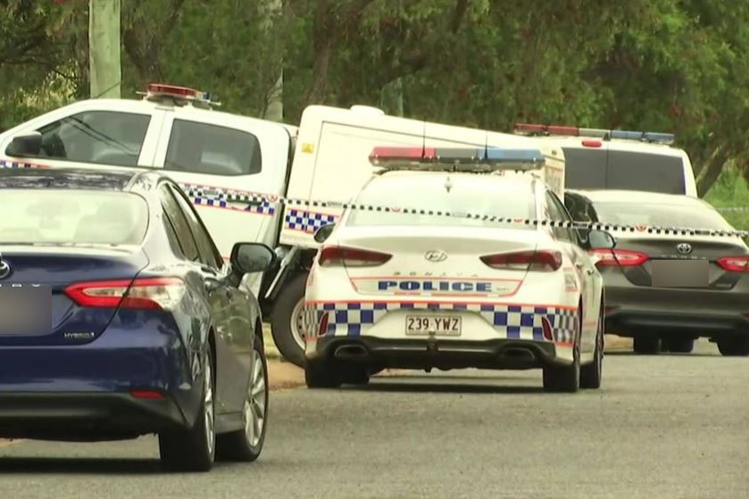 Police vehicles and police tape at the scene of the death of a 27-year-old man in Toowoomba
