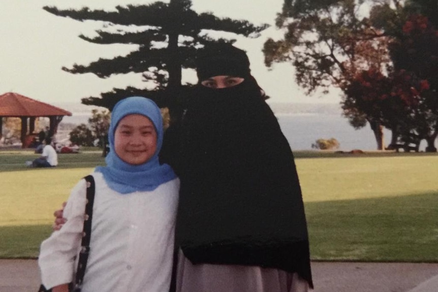 A photo of Aisha (right) with a friend on the (left). Aisha is wearing full niqab.