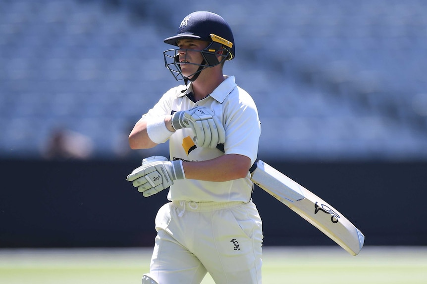 Marcus Harris returns to the pavilion with his bat under his left arm playing for Victoria at the MCG.