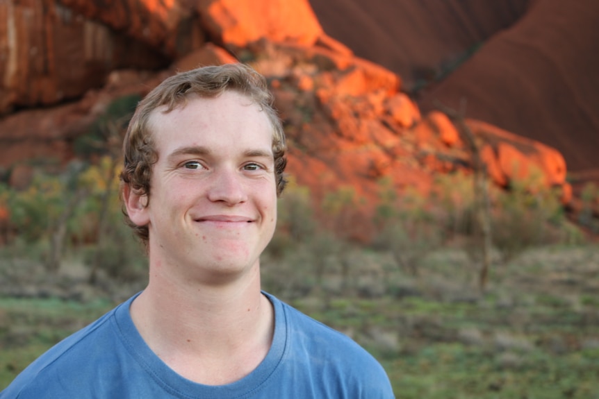 Tourism worker James Morris smiles in a portrait shot at the base of Uluru.