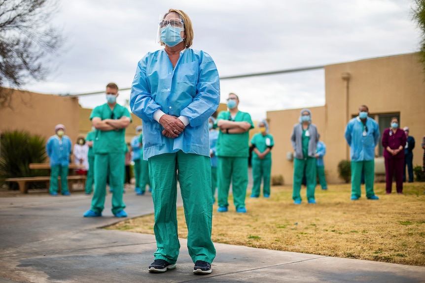 Arizona medical workers stand together at the front of a medial facility.