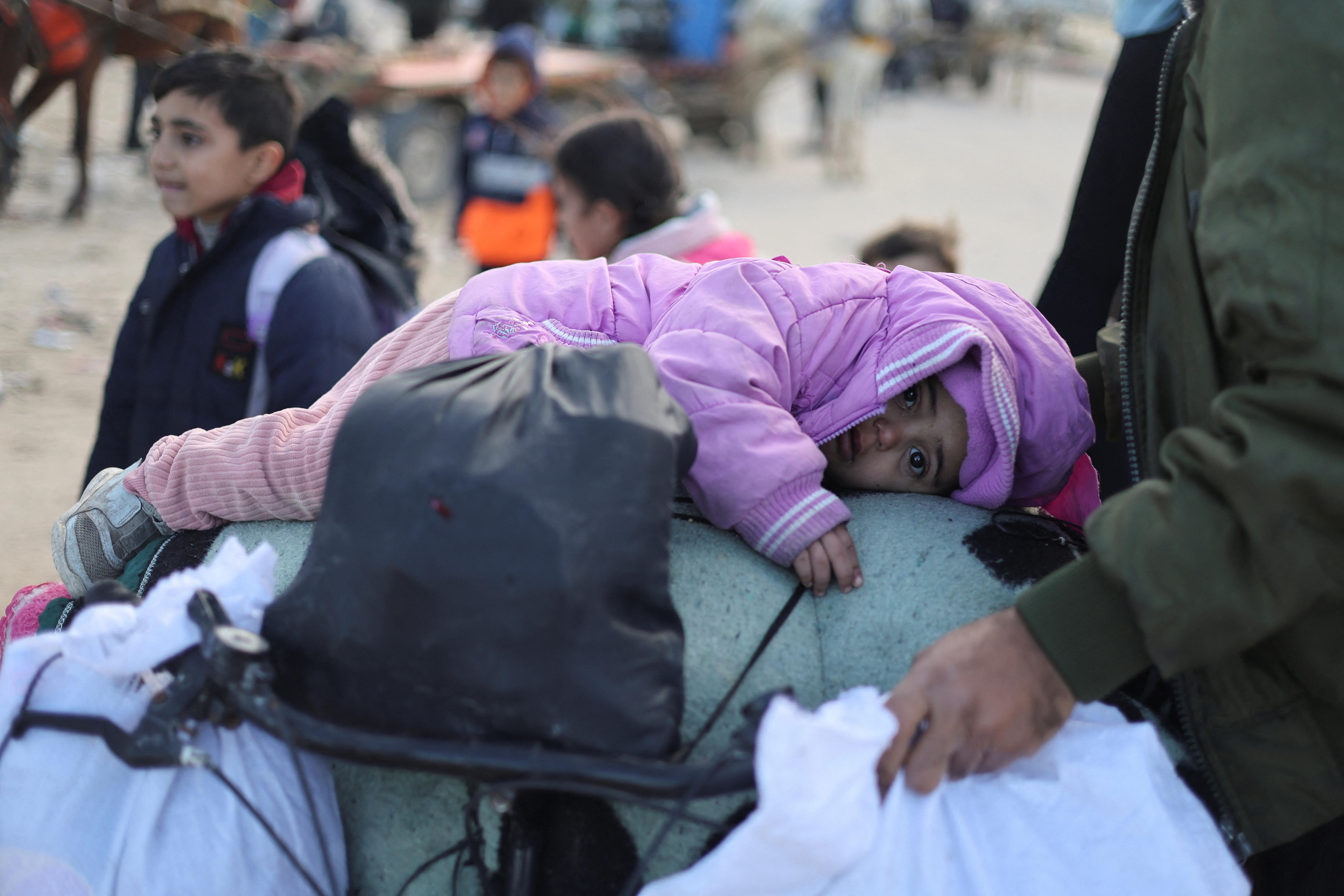 A baby in a pink jumpsuit lies on a bicycle 