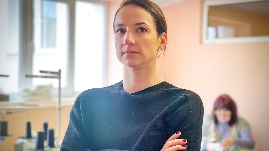 A woman with brown hair and wearing a black shirt stares off camera.