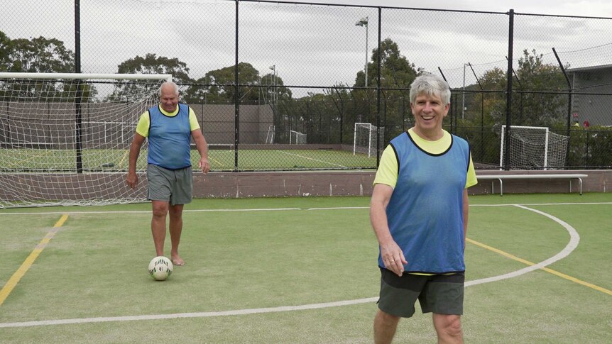Walking football players smiling during a game.