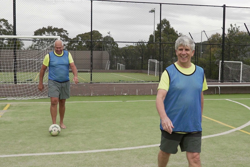 Walking football players smiling during a game.