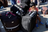 一名儿童在行李箱上休息