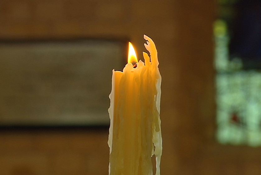 A candle burning inside a church.