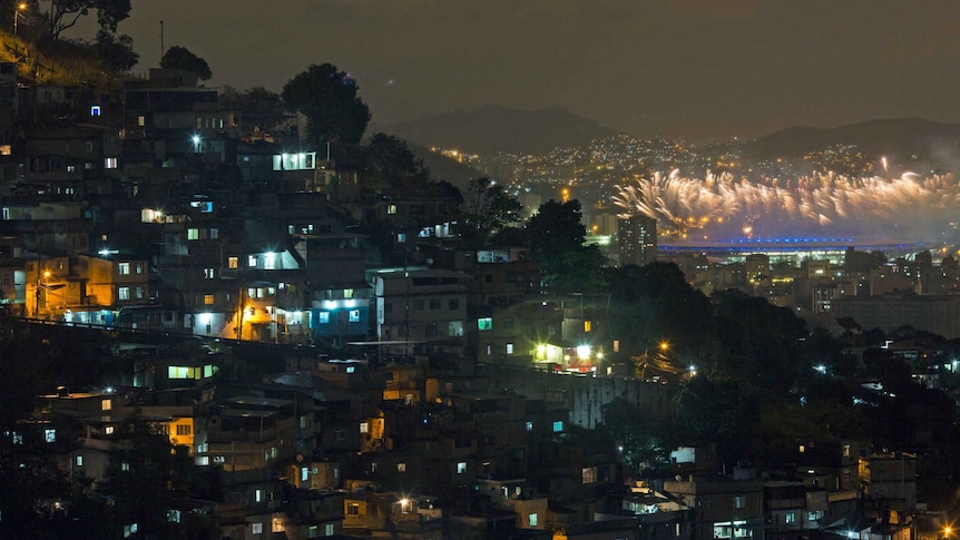 Closing ceremony fireworks explode over the Maracana stadium, kilometres behind the Morro dos Prazeres slum.