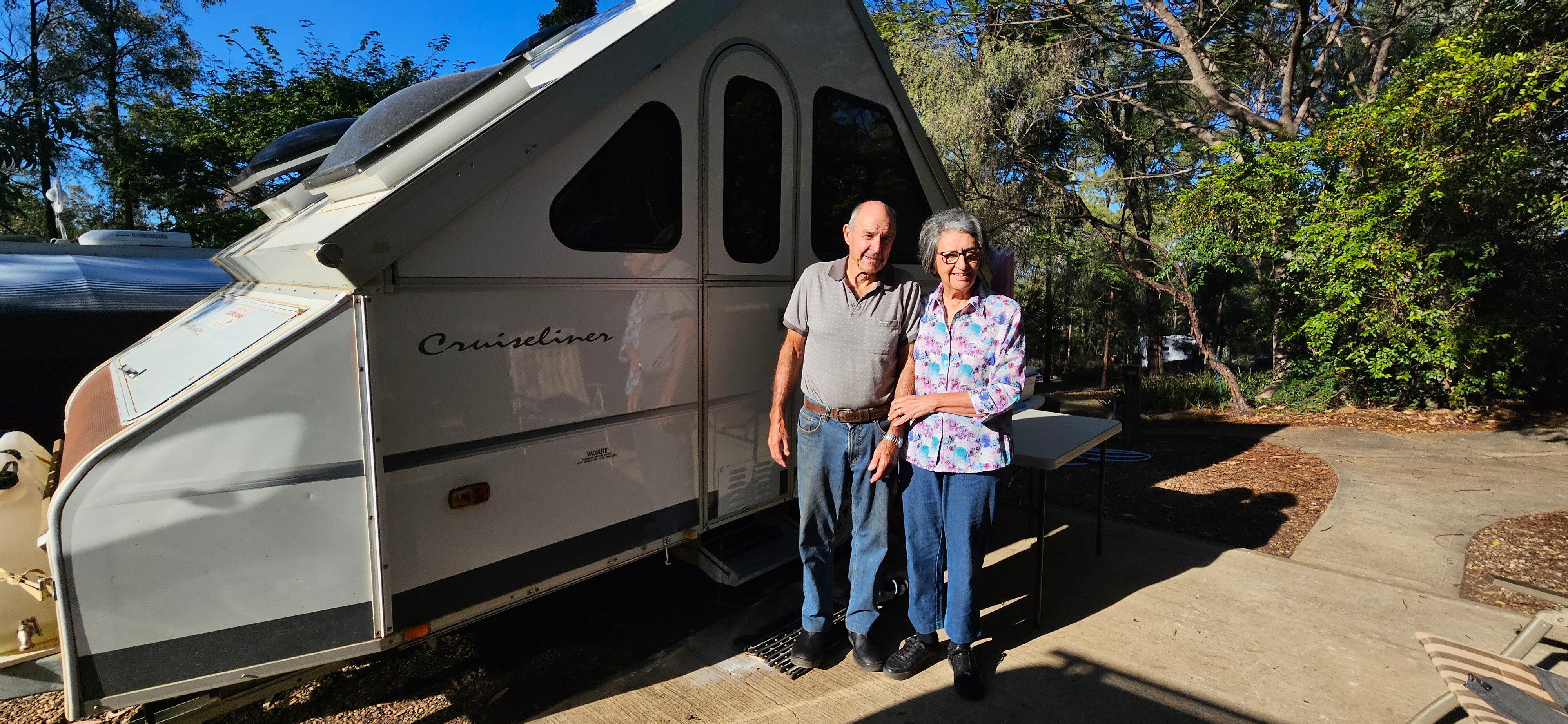 A woman and man in front of a caravan