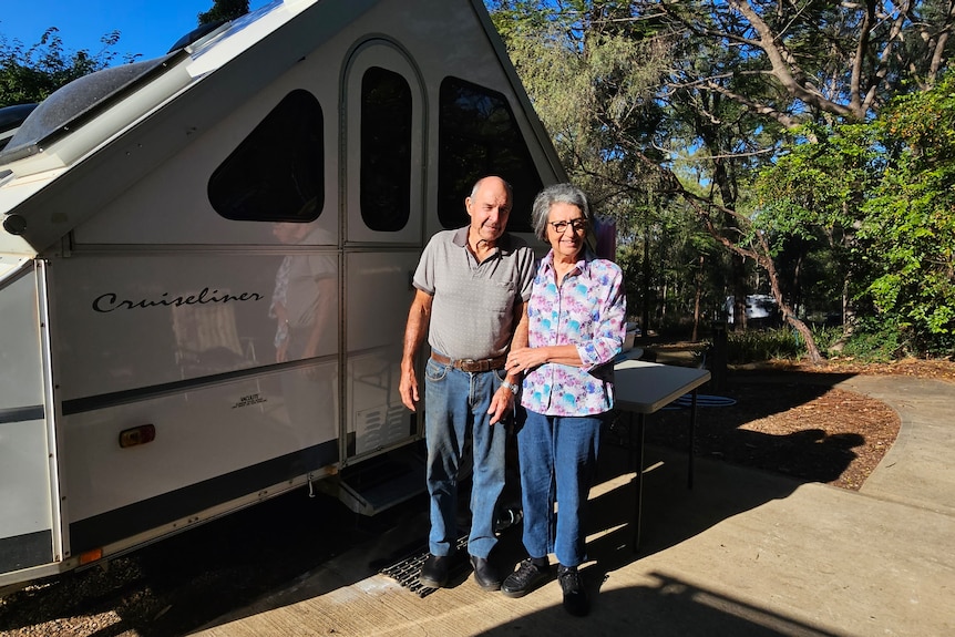 A woman and man in front of a caravan