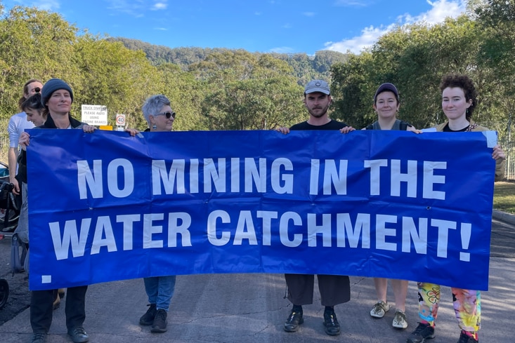 People holding a banner saying 'No mining in the water catchment'.