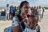 Mother and child wait to be evacuated in Indonesia