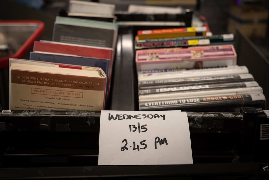 Stacks of books on trolleys with the date and time they were dropped off marked.