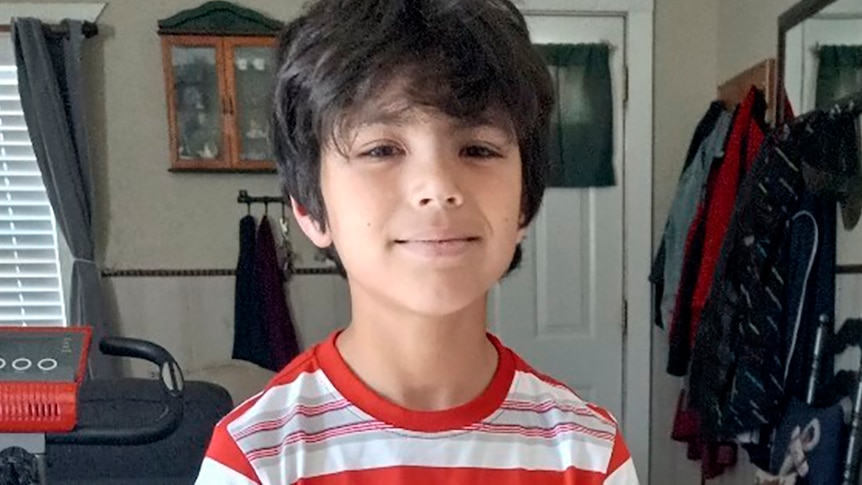 Uziyah Garcia poses in a house wearing a red and white striped top