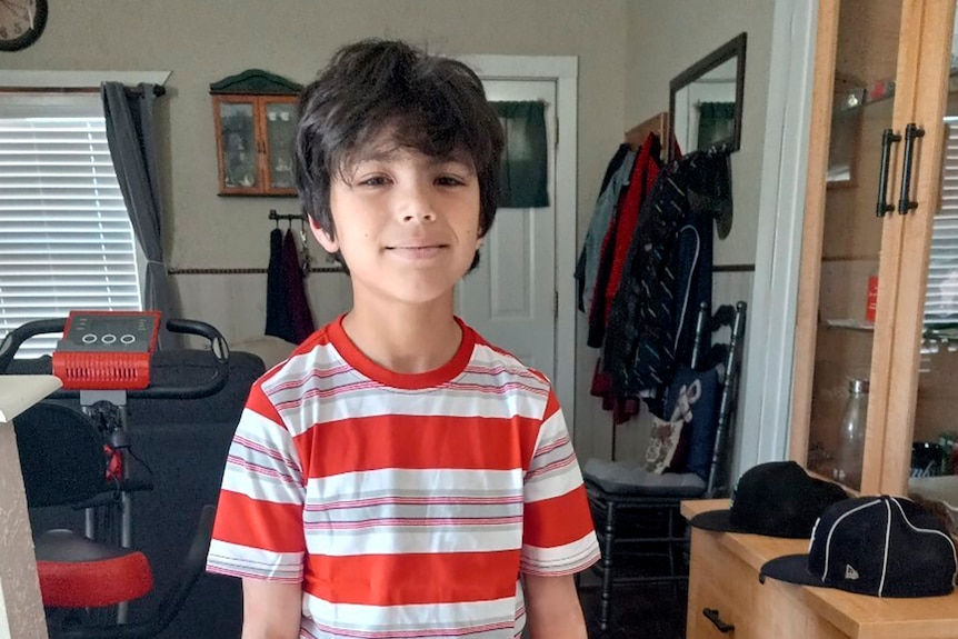 Uziyah Garcia poses in a house wearing a red and white striped top