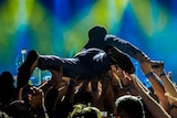 Lead singer of band crowdsurfs back to the stage.