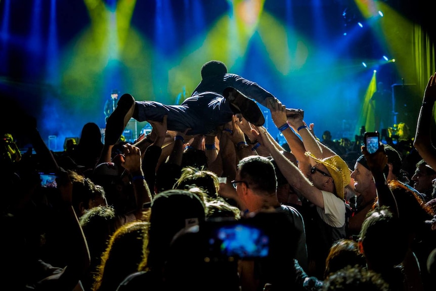 Lead singer of band crowdsurfs back to the stage.