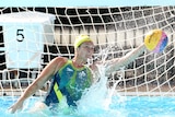 Water polo goalkeeper reaching out to save the ball from going in the net