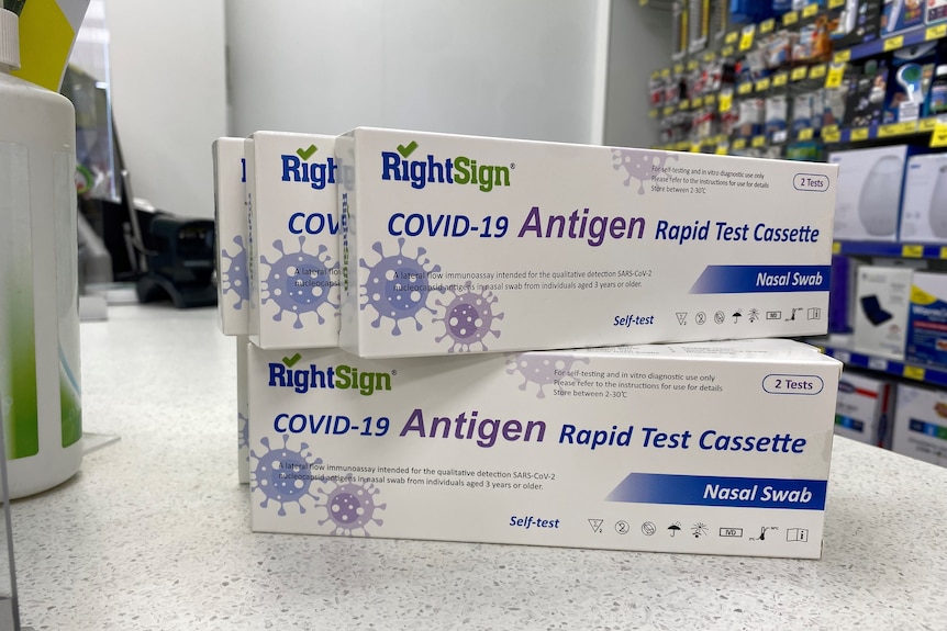Five boxes of rapid antigen tests stacked on a shop counter