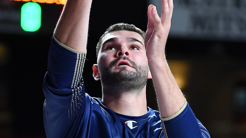 Isaac Humphries performs a lay-up while warming up before an NBL game for the Adelaide 36ers.