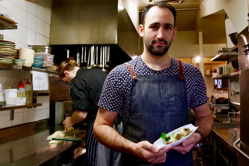 Abel Bariller holds a plate of escargot.