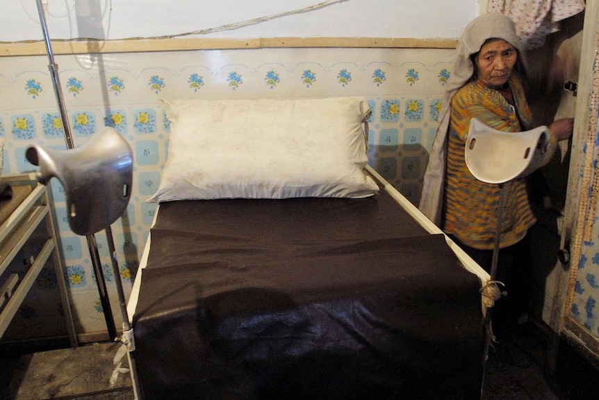 A cleaning lady prepares a bed at a ward in a gynaecology clinic where abortions are performed in the Afghan capital of Kabul