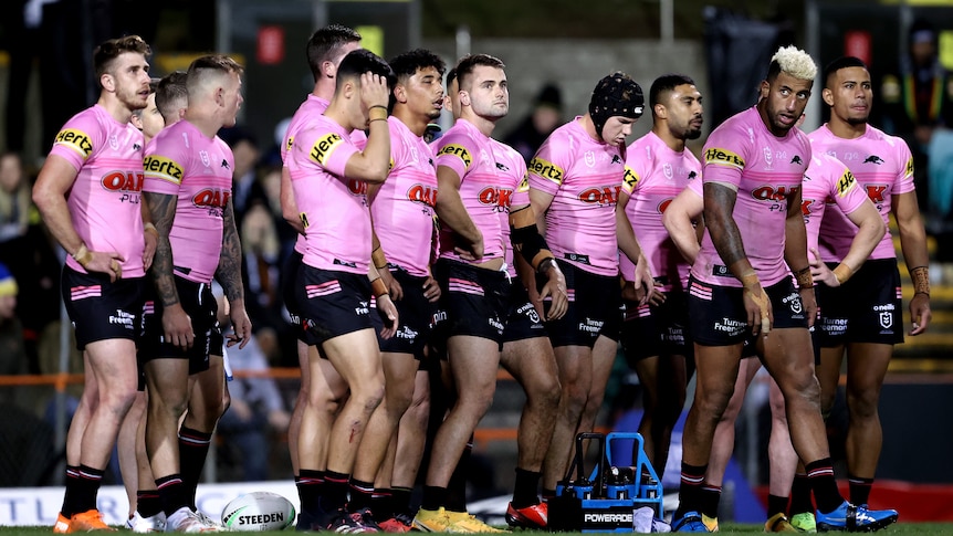 The entire Penrith Panthers NRL team stands behind their tryline looking into the distance after Wests Tigers scored another try