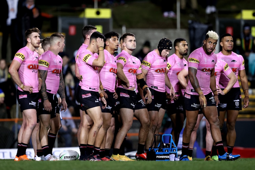 The entire Penrith Panthers NRL team stands behind their tryline looking into the distance after Wests Tigers scored another try