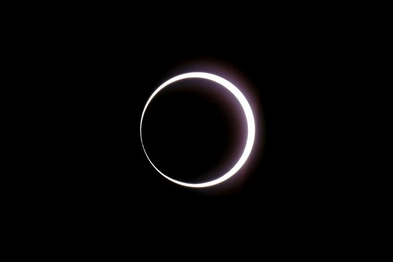 a black sky with a bright white ring in in the middle